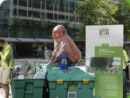 Ein Mädchen sitzt auf einer ShelterBox bei einer Werbeaktion.