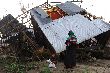 Einige M&auml;nner tragen eine ShelterBox einen Hang hinauf